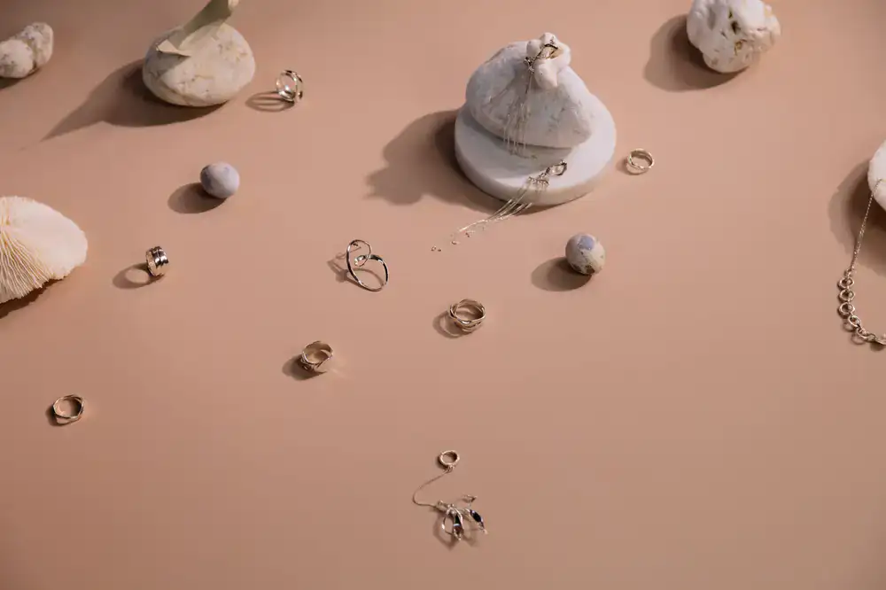 Minimalist silver and gold necklaces resting on natural stone
